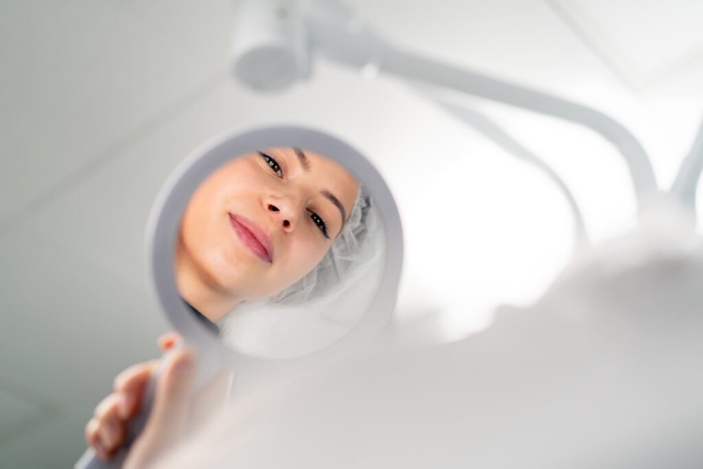 close-up of a satisfied face of a female client in a beauty salon looking in the mirror enjoying the result of cosmetic procedure